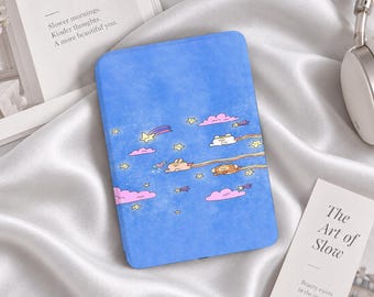 Könnte beinhalten: Eine blaue E-Reader-Hülle mit einer Illustration von kleinen Zeichentrickfiguren, die durch einen Nachthimmel voller rosa Wolken, gelber Sterne und Sternschnuppen fliegen. Das Design hat eine texturierte Optik auf hellblauem Hintergrund.