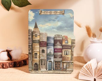 Könnte beinhalten: Rechteckige Dekorplatte mit einer Illustration von Gebäuden, die als Bücher gestaltet sind. Die Platte hat einen blauen Himmelshintergrund und den Text "THE WORLD OF BOOKS". Die Bücher sind in verschiedenen Farben und Stilen gehalten und schaffen eine skurrile Szene.