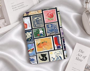 Könnte beinhalten: Ein rechteckiges Etui mit einer Collage aus alten Briefmarken verschiedener Länder. Die Briefmarken zeigen diverse Motive wie eine rote Tulpe, einen weißen Hasen, Orangen, eine schwarze Katze, Pinguine und architektonische Wahrzeichen.