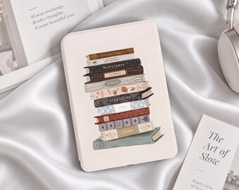 Könnte beinhalten: Eine hellrosa E-Reader-Hülle mit einer zentralen Illustration eines vertikalen Bücherstapels. Die Buchrücken zeigen Titel wie Midnights, reputation, 1989 und Fearless in verschiedenen Farben wie Braun, Grau, Blau und Creme.