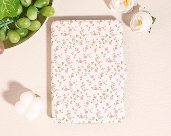 May include: A white tablet case with a delicate floral pattern of small pink roses and green leaves. The case is closed and has a magnetic clasp. The overall aesthetic is soft and feminine, suggesting a focus on style and protection for the device.
