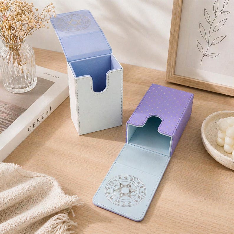 May include: Two open card storage boxes. One is white with a light blue interior, the other is purple with white polka dots. Both have a light blue interior and a decorative design on the lid.
