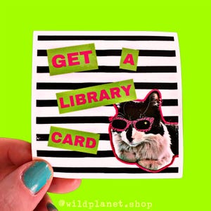 May include: A black and white cat wearing pink sunglasses on a white and black striped background with the text "GET A LIBRARY CARD" in green and pink letters.