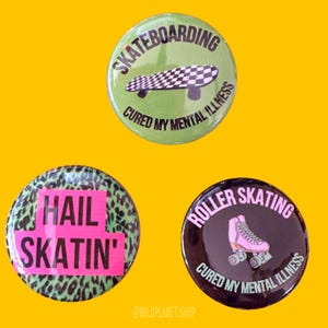 May include: Three round button pins with a green, black, and leopard print background. The green pin has a black and white skateboard with the text "Skateboarding Cured My Mental Illness". The black pin has a pink roller skate with the text "Roller Skating Cured My Mental Illness". The leopard print pin has the text "Hail Skatin'" in pink.