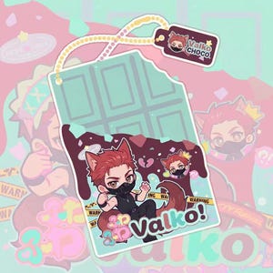 Puede incluir: Un dije rectangular de barra de chocolate verde menta con una marca de mordida, que presenta un personaje chibi con cabello rojo, orejas de lobo y una máscara negra. El diseño incluye chocolate derretido marrón oscuro y el texto Valko Choco.