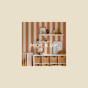 May include: A white shelf with a variety of toys and a framed picture on a wall with orange and white stripes. The text "WALLPAPER MOCKUP" is written in black on the wall. Below the shelf is a white cabinet with woven baskets.