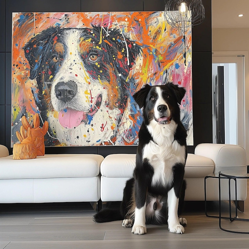 May include: A vibrant abstract painting of a dog with a black, white, and brown coat is displayed above a white sofa. A real dog with a similar coat sits in front of the sofa. An orange wooden sculpture sits on the sofa.