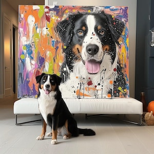 May include: A vibrant abstract painting of a Bernese Mountain Dog with paint splatter effects. A real Bernese Mountain Dog sits in front of the painting. The dog has black, white, and brown fur.