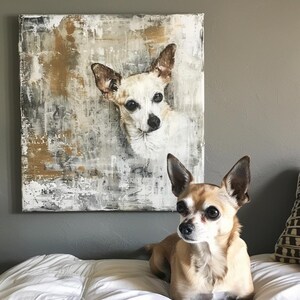 May include: An abstract painting of a Chihuahua dog with a white and brown coat hangs on a gray wall. A real Chihuahua dog with a similar coat color sits on a white bed in front of the painting.