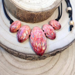 Collana modellata e dipinta a mano-composta da cinque elementi dalle formeorganiche e dai toni caldi del rosso