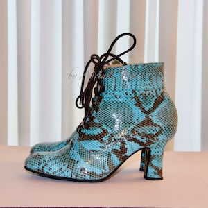 Peut inclure: Une paire de bottines à lacets en cuir de serpent bleu et marron à talons.