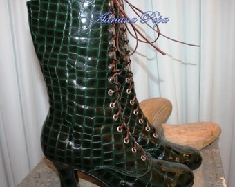 May include: Dark green, mid-calf boots with a glossy, crocodile-skin texture. The boots feature a lace-up design with brown laces and silver eyelets. They have a small, curved heel and a rounded toe. The boots are a unique fashion statement.