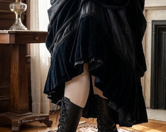 May include: A black velvet cape and a matching tiered skirt with braided trim, paired with black leather lace-up boots featuring a mid-height heel. The ensemble includes a pair of beige gloves, creating a cohesive dark-toned outfit.