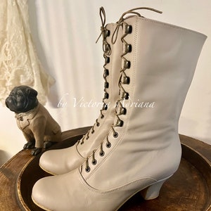 Pode incluir: Botas de renda de couro bege com salto baixo. As botas t&ecirc;m uma ponta arredondada e s&atilde;o feitas de um couro macio e flex&iacute;vel. Os cadar&ccedil;os s&atilde;o amarrados em um la&ccedil;o na parte superior da bota.
