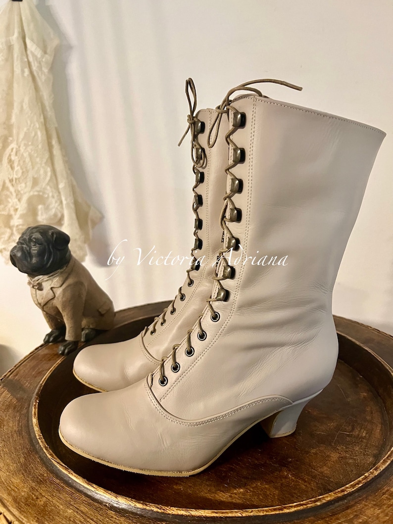 Pode incluir: Botas de renda de couro bege com salto baixo. As botas t&ecirc;m uma ponta arredondada e s&atilde;o feitas de um couro macio e flex&iacute;vel. Os cadar&ccedil;os s&atilde;o amarrados em um la&ccedil;o na parte superior da bota.