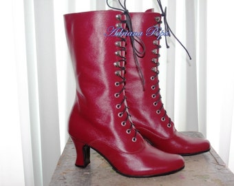 May include: A pair of red leather lace-up boots with a high heel. The boots have a shiny finish and are tied with black laces.
