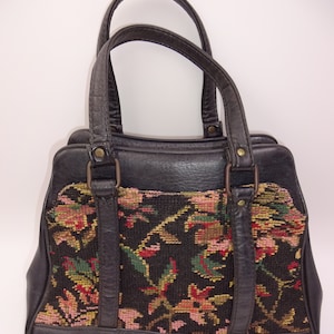 Bolso de mano vintage con tapiz floral negro y flores, con doble asa.