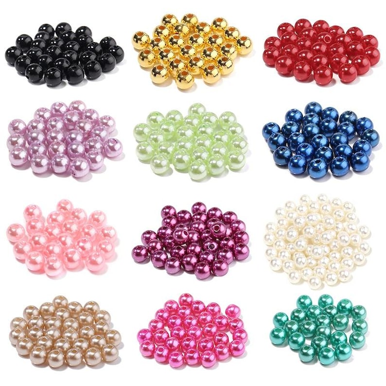 May include: Nine piles of round beads in various colors are displayed. Colors include black, gold, red, lavender, light green, blue, pink, dark purple, cream, tan, hot pink, and teal. The beads appear to be made of a glossy material.