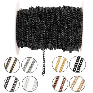 Puede incluir: Un carrete de cadena negra con un pequeño trozo de cadena colgando. La imagen también muestra muestras circulares de cadenas de diferentes colores, incluyendo oro, plata y bronce. Esta cadena es ideal para la fabricación de joyas.