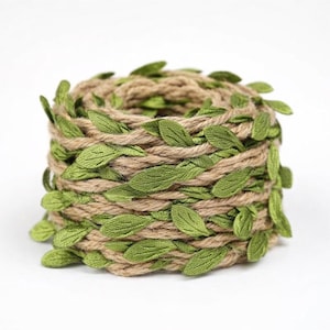 May include: A roll of natural jute twine wrapped with green fabric leaves. The twine is a light brown color, and the leaves are a vibrant green. The leaves are evenly spaced around the twine, creating a decorative effect. This item is suitable for crafts and decorations.