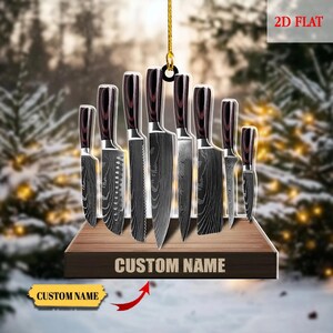 May include: A decorative knife set ornament with a wooden base and blades featuring a dark wood handle. The blades have a unique pattern. The ornament includes the text "CUSTOM NAME" and "2D FLAT".
