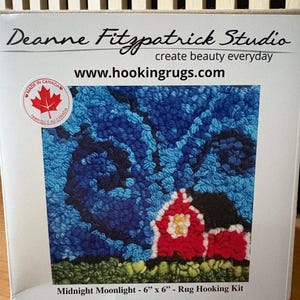 May include: A rug hooking kit featuring a red barn with a white roof and a dark roof, set against a blue night sky. The kit is labeled "Midnight Moonlight" and measures 6 inches by 6 inches. The kit is from Deanne Fitzpatrick Studio.