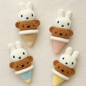 Op de afbeelding: Vier gehaakte ijshoorntjesspeeltjes. Elk speeltje heeft een witte konijnenkop, een bruin berenlichaam en een kleurrijke kegel. De kegels zijn in tinten geel, roze en blauw. De speeltjes zijn handgemaakt en hebben zwarte, geborduurde gezichtskenmerken.