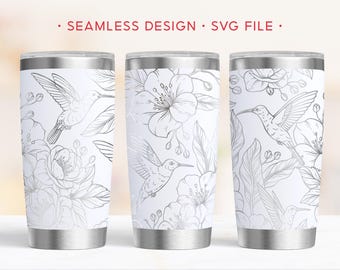 Könnte beinhalten: Drei weiße Edelstahlbecher mit silbernem Blumen- und Kolibri-Design. Die Becher haben ein nahtloses Muster mit dem Text "SEAMLESS DESIGN • SVG FILE" oben. Das Design zeigt detaillierte Strichzeichnungen von Kolibris und Blumen.