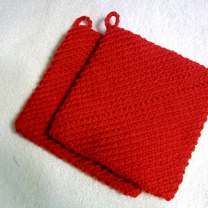 May include: Two red crocheted pot holders with a loop handle on each.