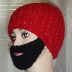 May include: A red knitted hat with a black knitted beard attached. The hat is made with a simple stitch pattern and has a slouchy fit.