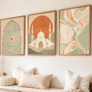 May include: Three framed wall art prints with a warm color palette. The prints feature an abstract design, a mosque illustration, and a geometric pattern. A bench with storage and decorative pillows is below the art. A stuffed bunny and pampas grass add to the room's decor.