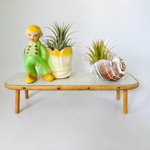 May include: A set of three ceramic mugs with a speckled, matte finish. The mugs are in shades of cream, light gray, and dark gray. Each mug has a simple, minimalist design, perfect for coffee or tea.