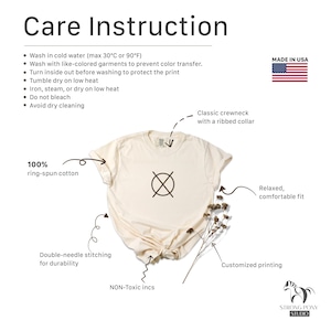 Puede incluir: Camiseta color crema con instrucciones de cuidado y bandera de EE. UU. Incluye cuello redondo cl&aacute;sico, costuras de doble aguja y un ajuste relajado. La camiseta est&aacute; hecha de 100% algod&oacute;n hilado en anillos y tiene impresi&oacute;n personalizada. El texto en la camiseta dice "Care Instruction".