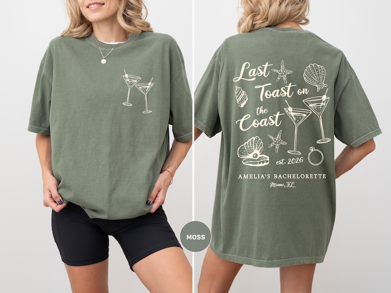 K&ouml;nnte beinhalten: Moosgr&uuml;nes T-Shirt mit einer Grafik von zwei Martinigl&auml;sern auf der Vorderseite. Auf der R&uuml;ckseite steht der Text "Last Toast on the Coast" mit Muschel- und Seestern-Illustrationen sowie der Text "est. 2026" und "AMELIA'S BACHELORETTE Miami, FL".