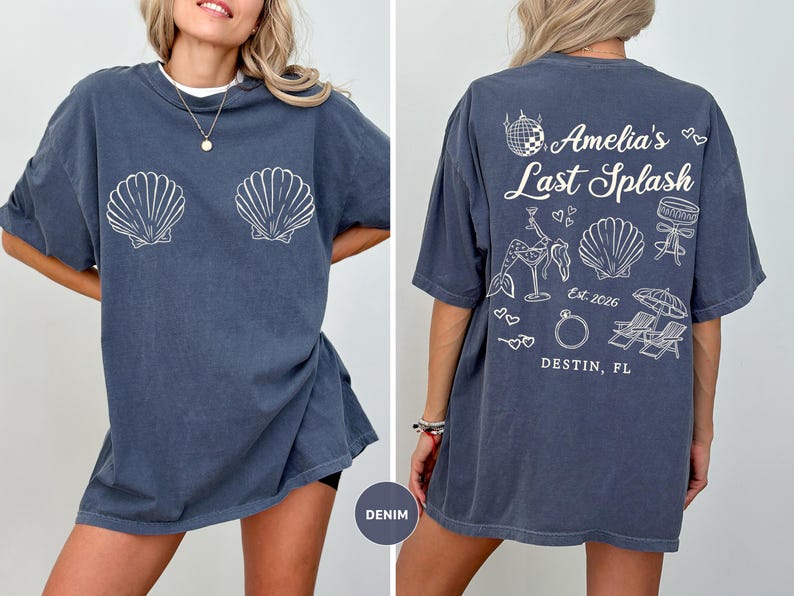 Puede incluir: Camiseta azul denim con gr&aacute;ficos de conchas blancas en la parte delantera. La parte trasera de la camiseta presenta el texto "Amelia's Last Splash" con ilustraciones de una bola de discoteca, una sirena y un anillo. Tambi&eacute;n es visible el texto "Destin, FL".
