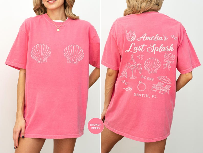 Puede incluir: Una camiseta rosa con gr&aacute;ficos de conchas blancas en la parte delantera. La parte trasera de la camiseta presenta el texto "Amelia's Last Splash" con ilustraciones tem&aacute;ticas de playa y la ubicaci&oacute;n "Destin, FL".