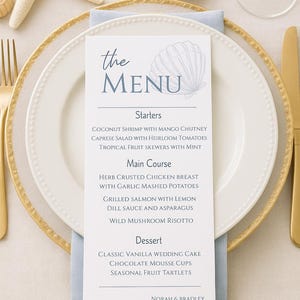 May include: An elegant table setting featuring a menu card with the words "the MENU" and a seashell illustration. The menu lists starters, main courses, and desserts. A gold-rimmed plate, gold cutlery, and seashells are also visible.