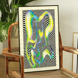 Op de afbeelding: Een ingelijste abstracte kunstprint met een zwart-wit gestreepte achtergrond en kleurrijke, vloeiende vormen in tinten blauw, groen en geel. De print wordt getoond op een houten stoel. Een bord met het woord "DANGER" is zichtbaar.