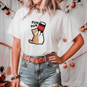 Camiseta de gato fofo bebendo refrigerante Kawaii DUN DUN camiseta engraçada de gato desenho animado presente para amantes de gatos
