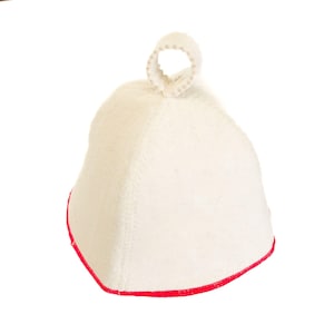 May include: A white sauna hat with a red trim and a loop at the top. The hat is made of a thick, textured material and is designed to protect the head from heat.
