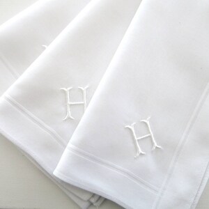 May include: Three white linen handkerchiefs with a single initial, "H", embroidered in the corner of each.