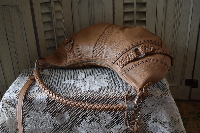 Pu&ograve; includere: Una tazza di ceramica bianca con manico nero e la scritta "But First, Coffee" in nero, con un carattere a mano. La tazza &egrave; su una superficie bianca.