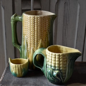 May include: A handmade wooden sign with the text "Welcome" in a playful font. The sign is painted white with a distressed finish, and features a decorative floral design in shades of pink and green. It measures approximately 12 inches wide.