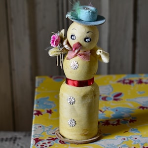 May include: A white ceramic mug with a black handle and the text "But First, Coffee" in a black, handwritten-style font. The mug is on a white surface.