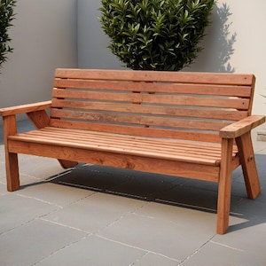 K&ouml;nnte beinhalten: Eine Holzbank mit nat&uuml;rlichem Finish. Die Bank hat eine Lattenlehne und -sitzfl&auml;che mit Armlehnen. Die Bank ist etwa 152 cm lang und aus Holz gefertigt. Die Bank befindet sich im Freien auf einer Terrasse.