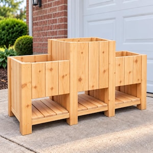 May include: A light brown wooden planter box featuring three distinct sections of varying heights. The structure is built from vertical cedar planks with a natural grain finish, including lower slatted shelves beneath each of the three planting compartments.