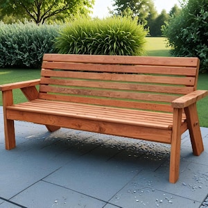 K&ouml;nnte beinhalten: Eine Gartenbank aus Holz mit nat&uuml;rlicher Oberfl&auml;che. Die Bank hat eine Lattenlehne und -sitzfl&auml;che mit Armlehnen. Sie ist aus hellbraunem Holz gefertigt und steht auf einer Terrasse mit einem gr&uuml;nen Rasen im Hintergrund.