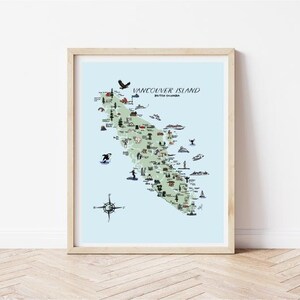 K&ouml;nnte beinhalten: Ein gerahmter Druck von Vancouver Island, British Columbia, Kanada. Die Karte ist gr&uuml;n mit blauem Wasser und zeigt Illustrationen von Sehensw&uuml;rdigkeiten und Wildtieren. Der Text "Vancouver Island" und "British Columbia" steht oben. Der Rahmen ist hellbraun.