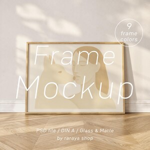 May include: A framed art print mockup featuring a minimalist illustration of a woman and a dog in beige tones. The wooden frame is rectangular. Text on the image reads "Frame Mockup" and "9 frame colors". The image is on a wooden floor.