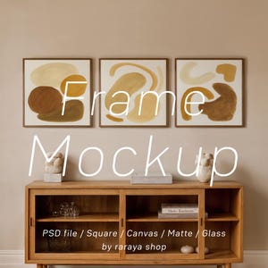 May include: Three square framed art prints with abstract shapes in shades of brown, beige, and yellow. Below, a wooden cabinet with glass doors displays decorative items. The text "Frame Mockup" is overlaid on the image.